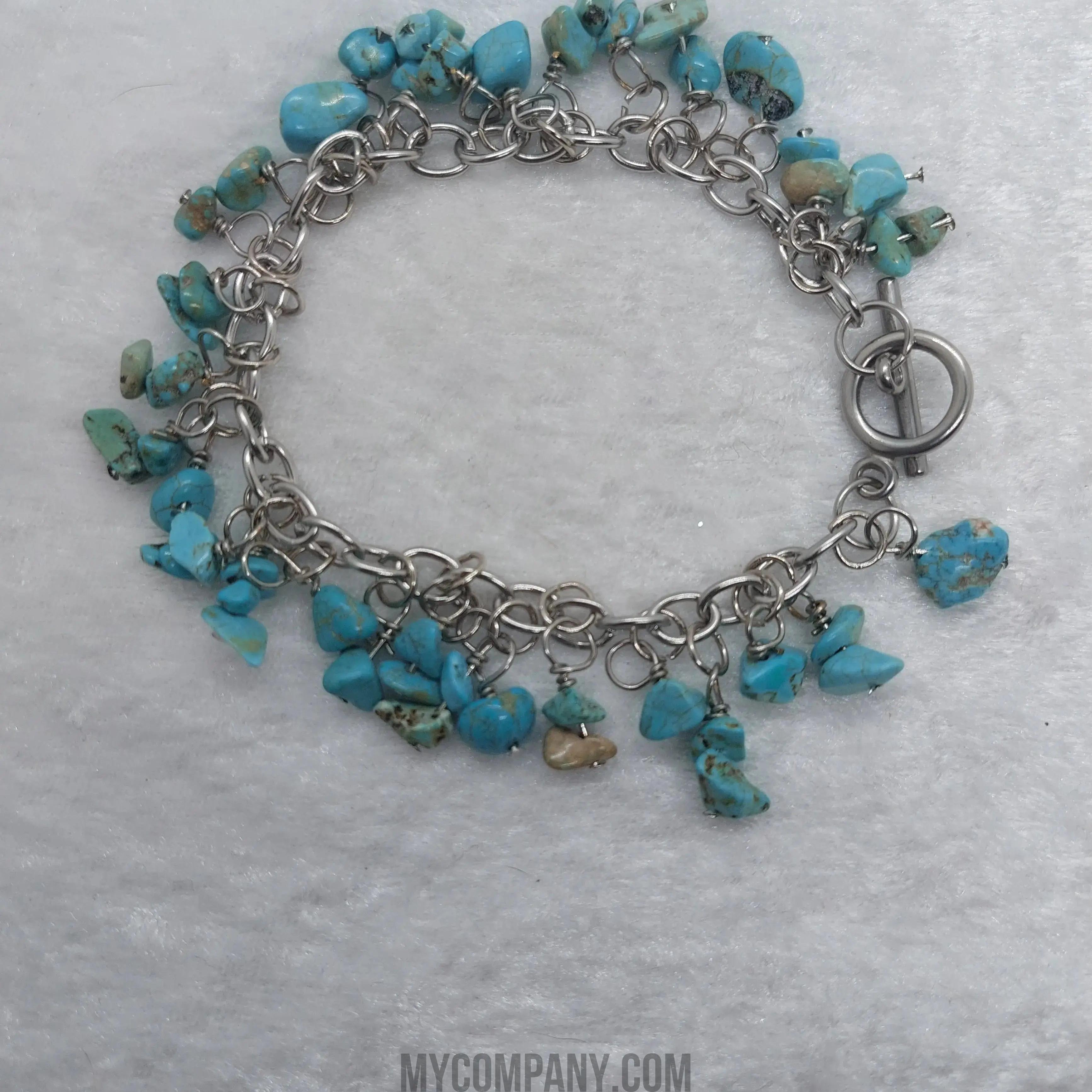 Silver stainless steel charm bracelet with numerous turquoise gemstone chips and a toggle clasp.