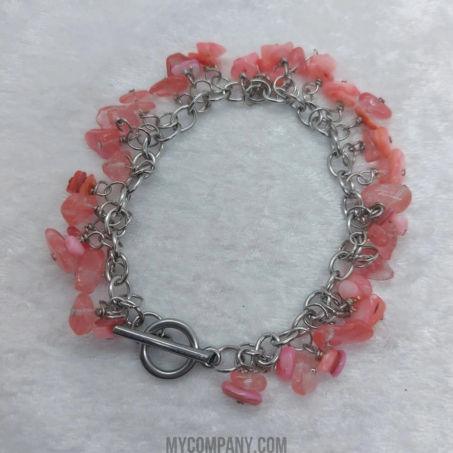 8-inch stainless steel bracelet with pink coral chip gemstone dangle charms and a toggle clasp.