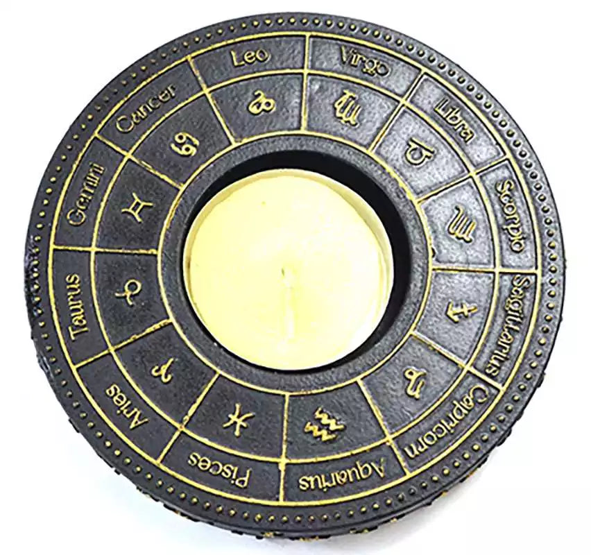 Circular metal tealight candle holder with 12 zodiac signs in gold relief on black finish for astrological altar décor