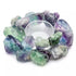 A circular arrangement of colorful fluorite crystals in shades of green and purple surrounds a clear glass dish. The crystals are rough and unpolished, showcasing their natural beauty.