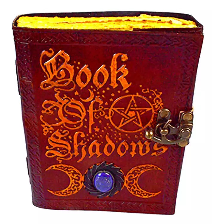 Aged leather-look Book of Shadows journal with metal latch, featuring embossed occult symbolism, for Wiccan grimoire and spell record keeping.