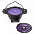 Small black cast iron cauldron holding a purple lavender-scented candle, with a circular pentagram label on the front.