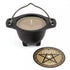 Black cauldron-shaped candle with handle sitting next to a circular coaster featuring a pentagram design, sandalwood scented altar ritual candle
