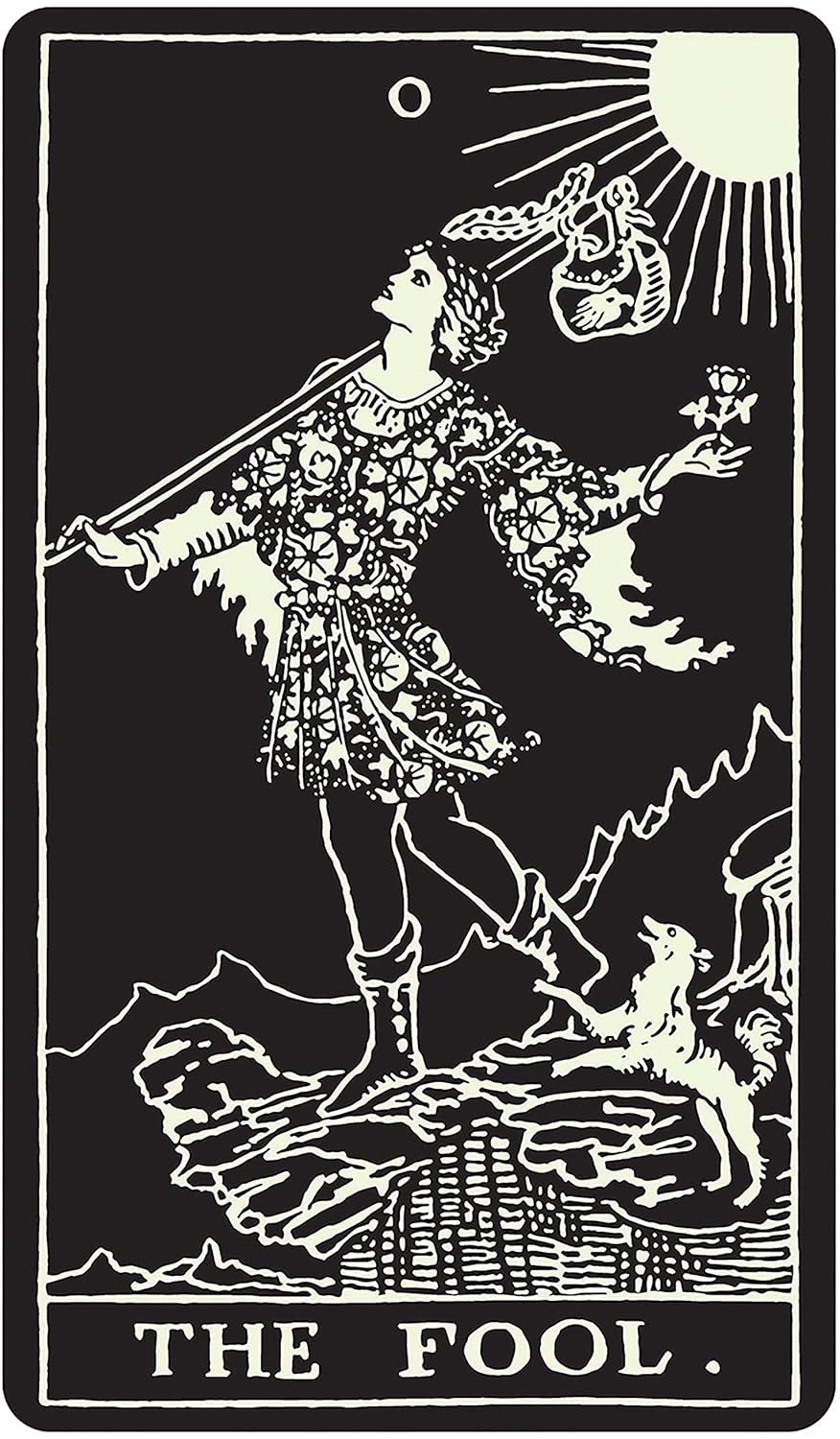 Glow-in-the-dark Tarot card showing The Fool — a figure on a cliff holding a flower, with a dog beside them, in glowing lines on black.