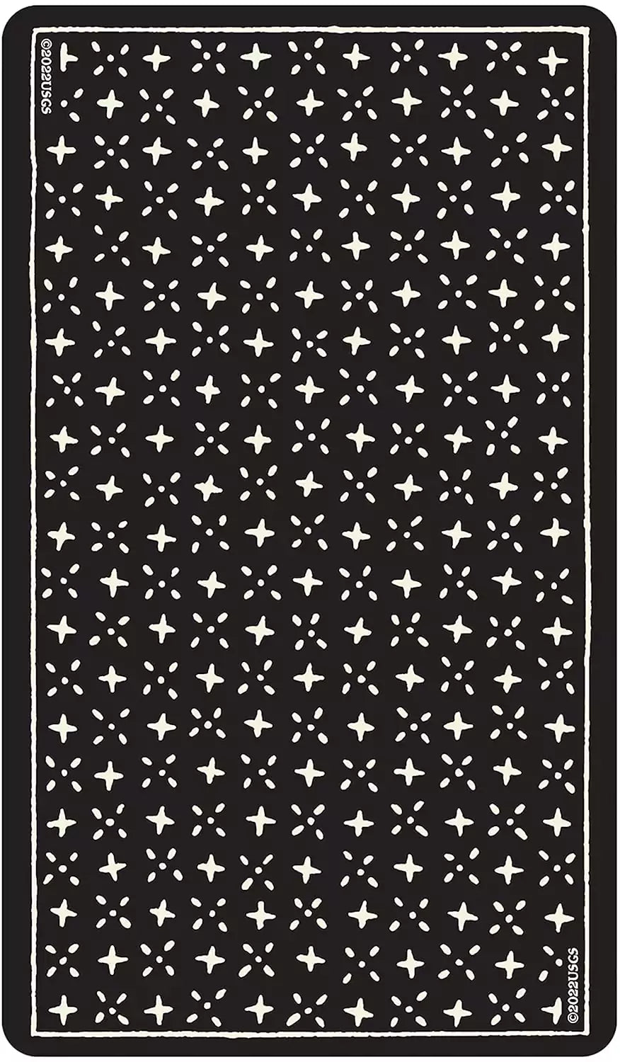 Dark surface showing the back design of the Glow in the Dark Tarot cards — a repeating pattern of small white stars on black.