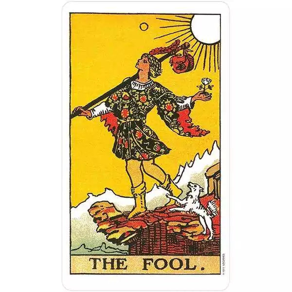 Rider-Waite Tarot Fool card — colorful figure in motley stands on a rocky ledge holding a small bundle, from the Restored Edition deck.