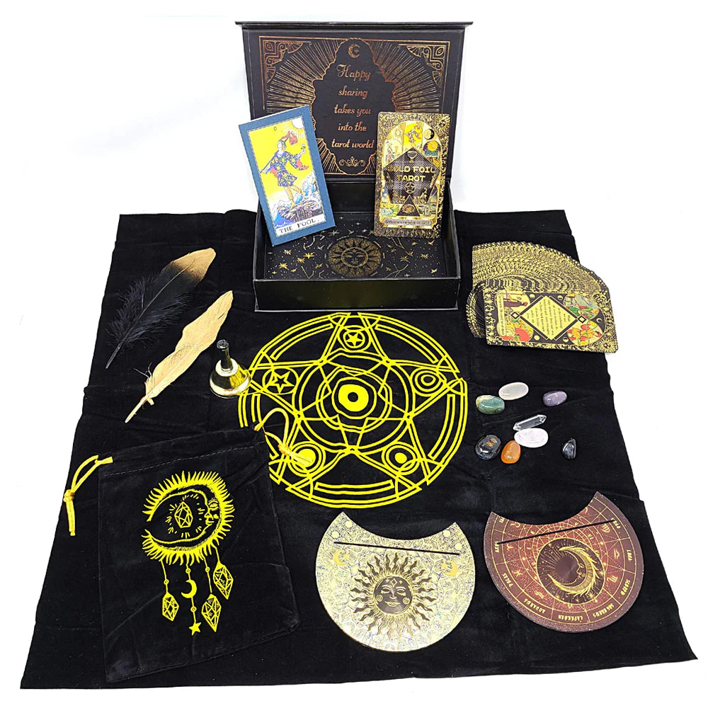 Collection of RWS gold foil tarot cards, crystals, feathers, and decorative circular pieces arranged on black cloth with a yellow pentagram design.