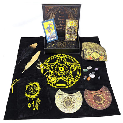 Collection of RWS gold foil tarot cards, crystals, feathers, and decorative circular pieces arranged on black cloth with a yellow pentagram design.