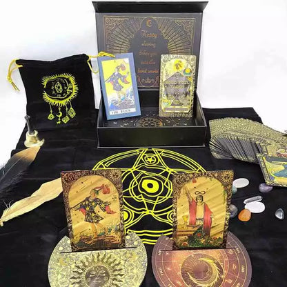 Rider-Waite black and gold foil tarot cards displayed on black cloth with crystals, a feather, and a decorative box showing mystical tarot imagery.