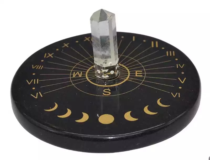 3-inch polished black agate sun clock altar tile with a quartz crystal center and golden cardinal direction markings — a ritual disc for altar and crystal grid use.