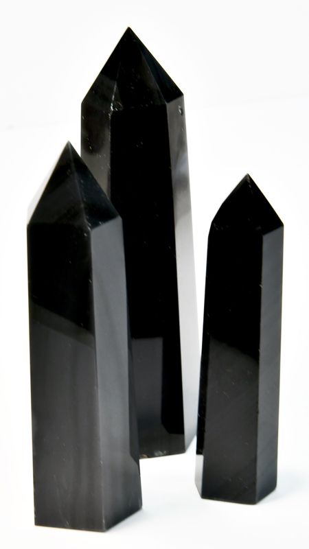 One pound bulk lot of silver sheen black obsidian obelisk towers ranging 3 to 4 inches, showing jet-black volcanic glass with internal silver metallic sheen flash.