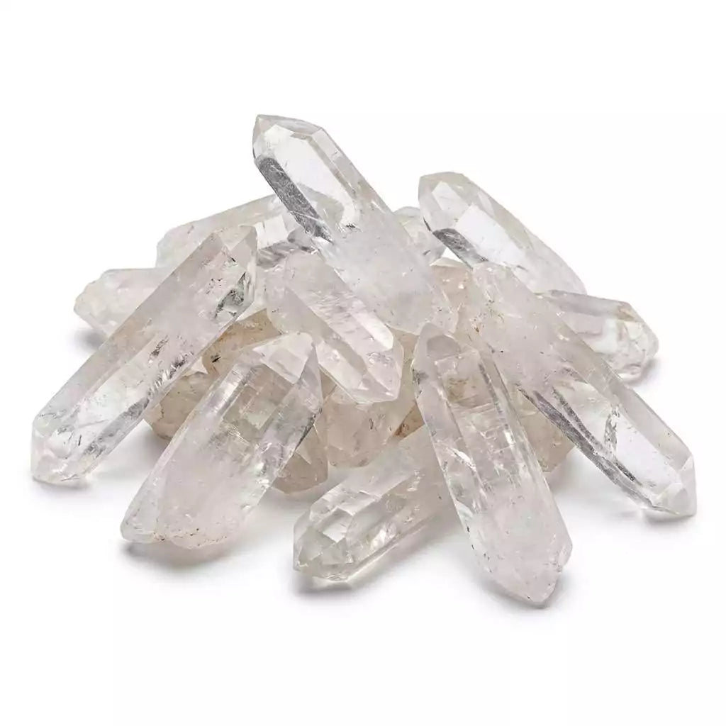 One pound lot of natural clear quartz crystal points 3 to 5 inches piled together with transparent pointed tips reflecting light — for grids, altars, and energy work.