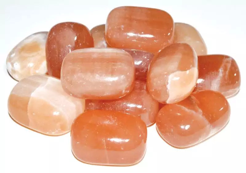 A collection of honey calcite tumbled stones in warm amber-golden tones, sold in 1 lb bulk for solar plexus chakra work and personal empowerment crystal practice.