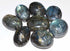 Large 2-inch polished labradorite tumbled stones in pile showing vivid blue and green labradorescence flash, one pound bulk lot