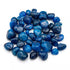 Blue onyx tumbled stones in a pile showing smooth polished surfaces with deep teal coloring — heat-treated chalcedony bulk crystals.