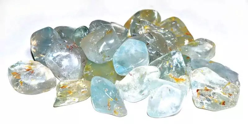 A collection of polished blue topaz tumbled stones in sky-blue and pale azure tones, sold in 1 lb bulk for throat chakra and stress-relief crystal work.