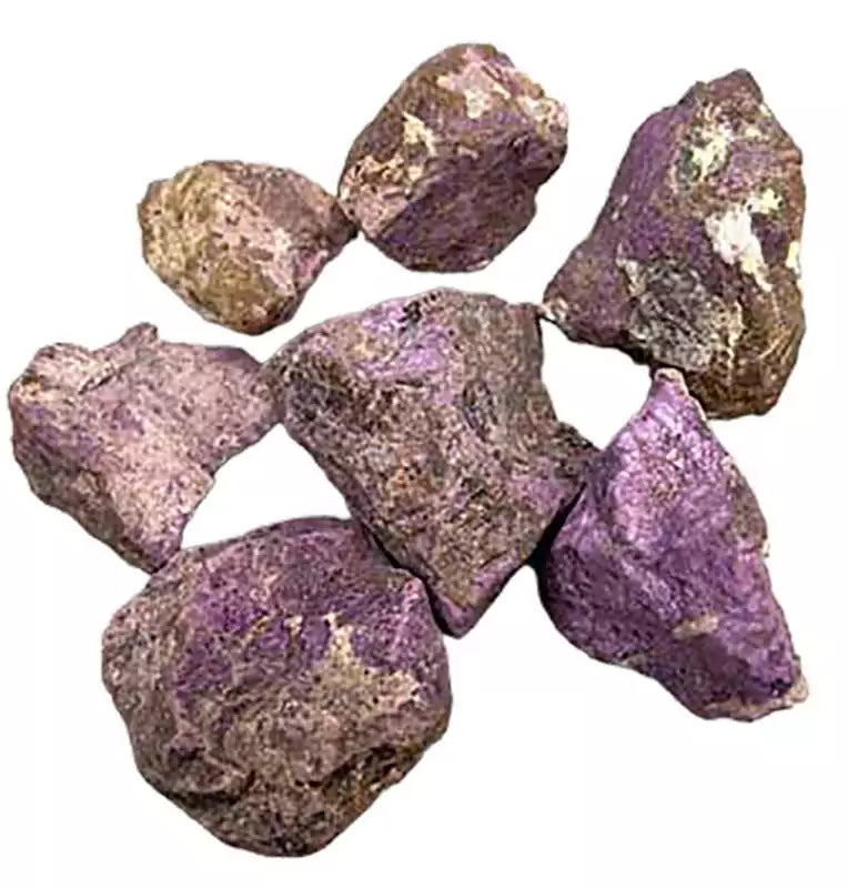 Collection of raw purple purpurite untumbled crystal stones in various sizes scattered for display bulk 1 pound lot for crystal grids and ritual use