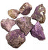 Collection of raw purple purpurite untumbled crystal stones in various sizes scattered for display bulk 1 pound lot for crystal grids and ritual use