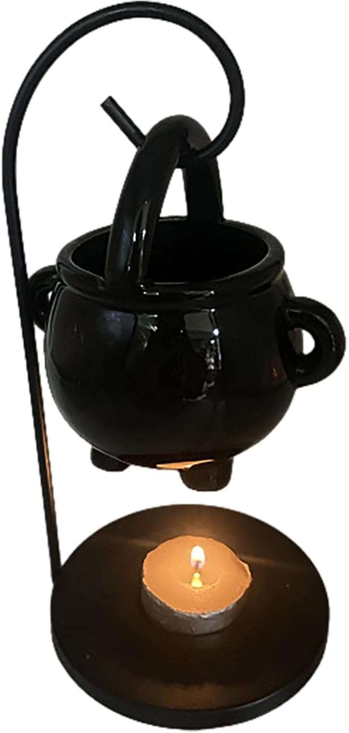Hanging cauldron diffuser showing the interior tealight candle holder and perforated metal walls that allow fragrant smoke to escape during ritual use.