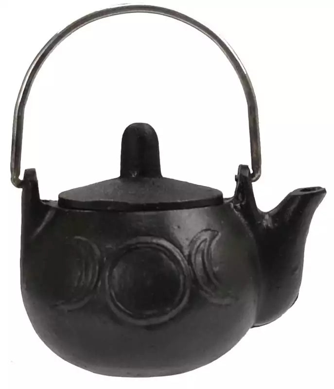 Small black cast iron cauldron with rounded body and handle featuring embossed crescent moon designs, three-legged base shown on white background