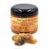 2oz jar of palo santo granular resin incense with loose resin pieces scattered beside it, for use on charcoal discs in ritual burning.