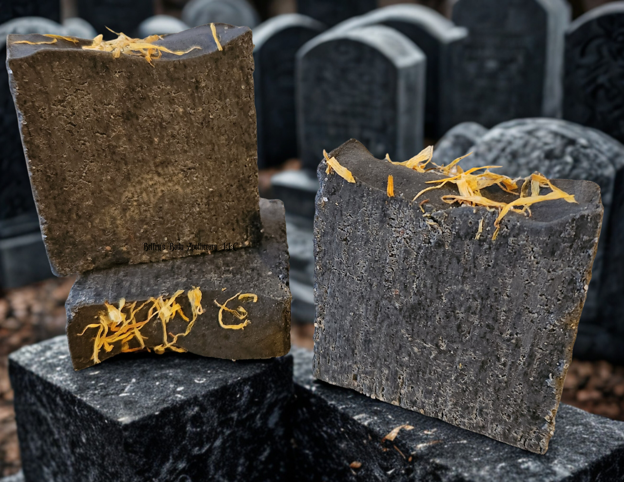 Cleansing collection - Three activated charcoal salt soap bars with yellow calendula petals on top.