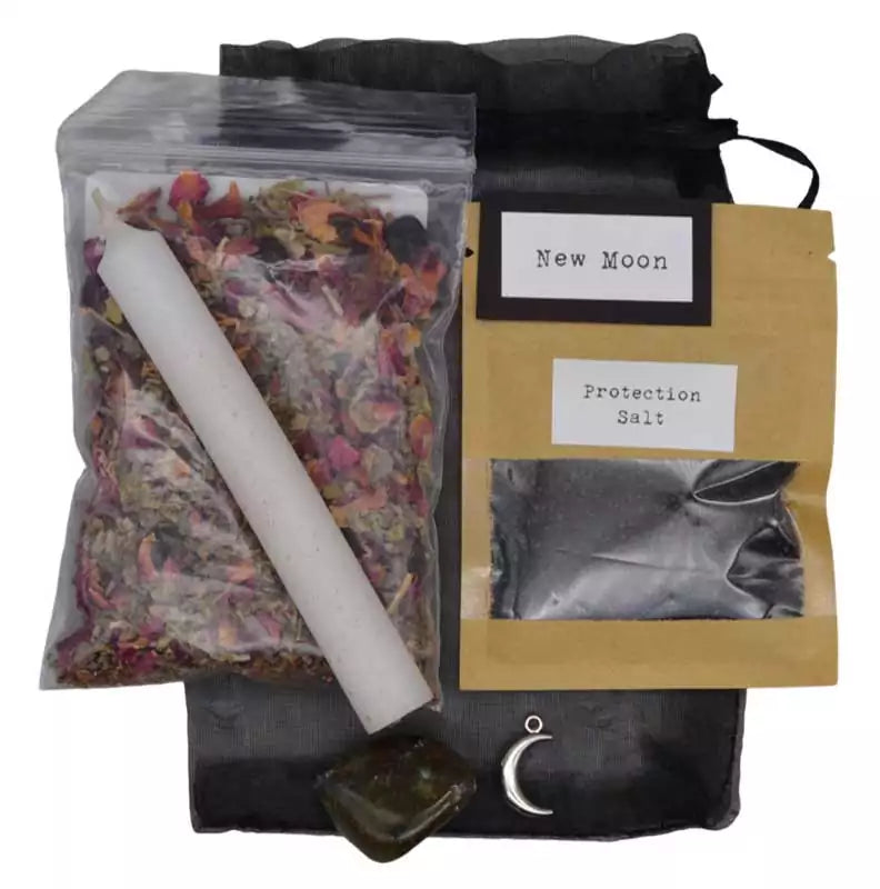 New Moon ritual kit contents showing a white candle, dried flower petals, crystals, and smudge components laid out for a complete lunar manifestation ceremony.