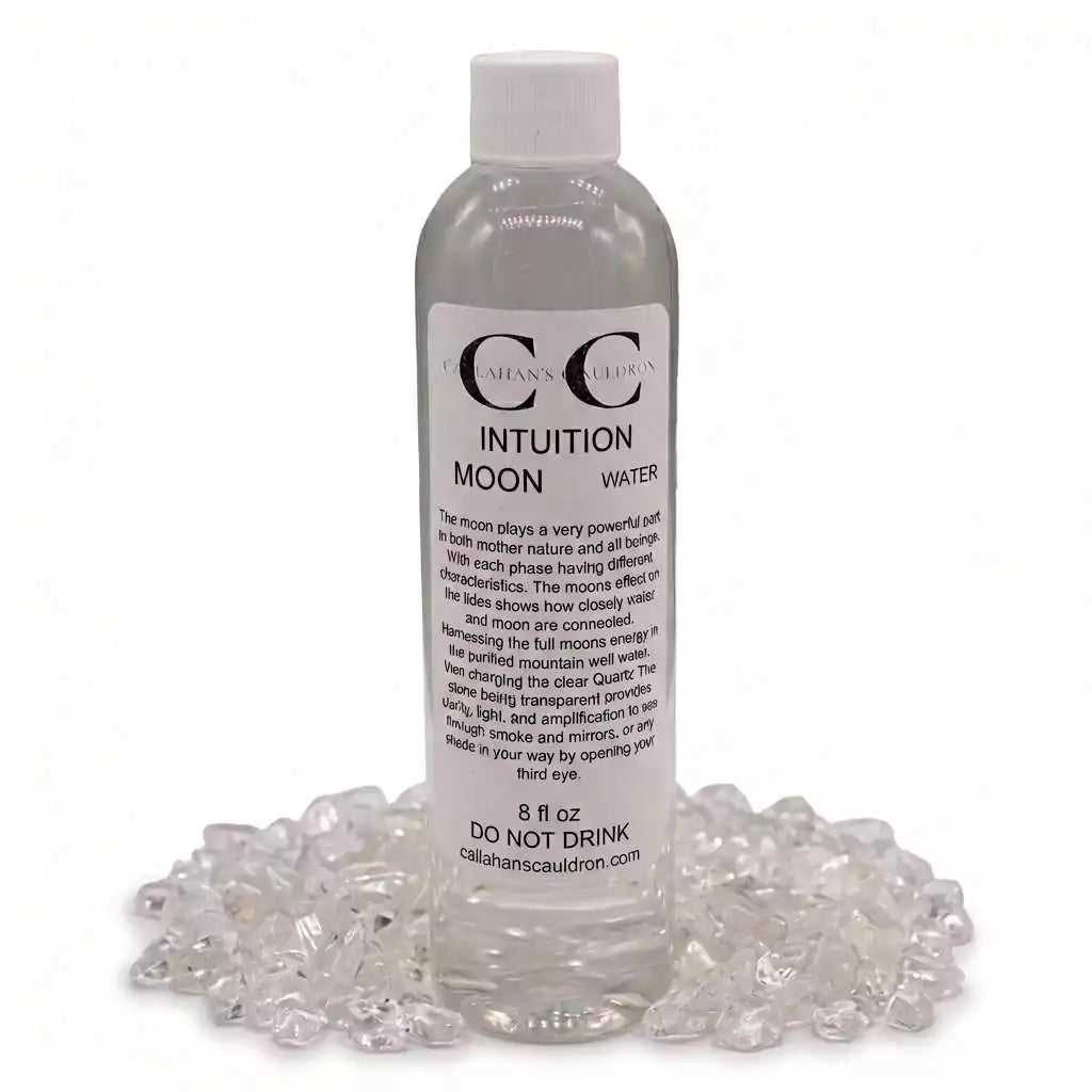 8oz Intuition Moon Water clear bottle labeled with crystal and moon imagery, sitting on a bed of small shiny crystals for psychic clarity and ritual practice.