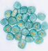 25-piece amazonite Elder Futhark rune set with teal gemstone tiles engraved with gold-filled runic symbols arranged beside a wooden box for Norse divination practice.