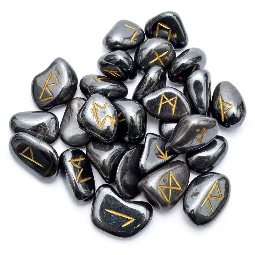 Hematite rune set showing 25 carved Elder Futhark rune stones in polished dark silver hematite displayed with rune symbols facing up.