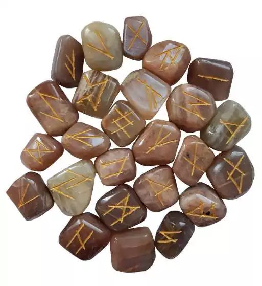 Collection of moonstone rune stones with Elder Futhark symbols carved into polished iridescent surfaces — lunar divination set.