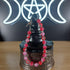 Pink and red glass bead bracelet with evil eye charms and a toggle clasp.