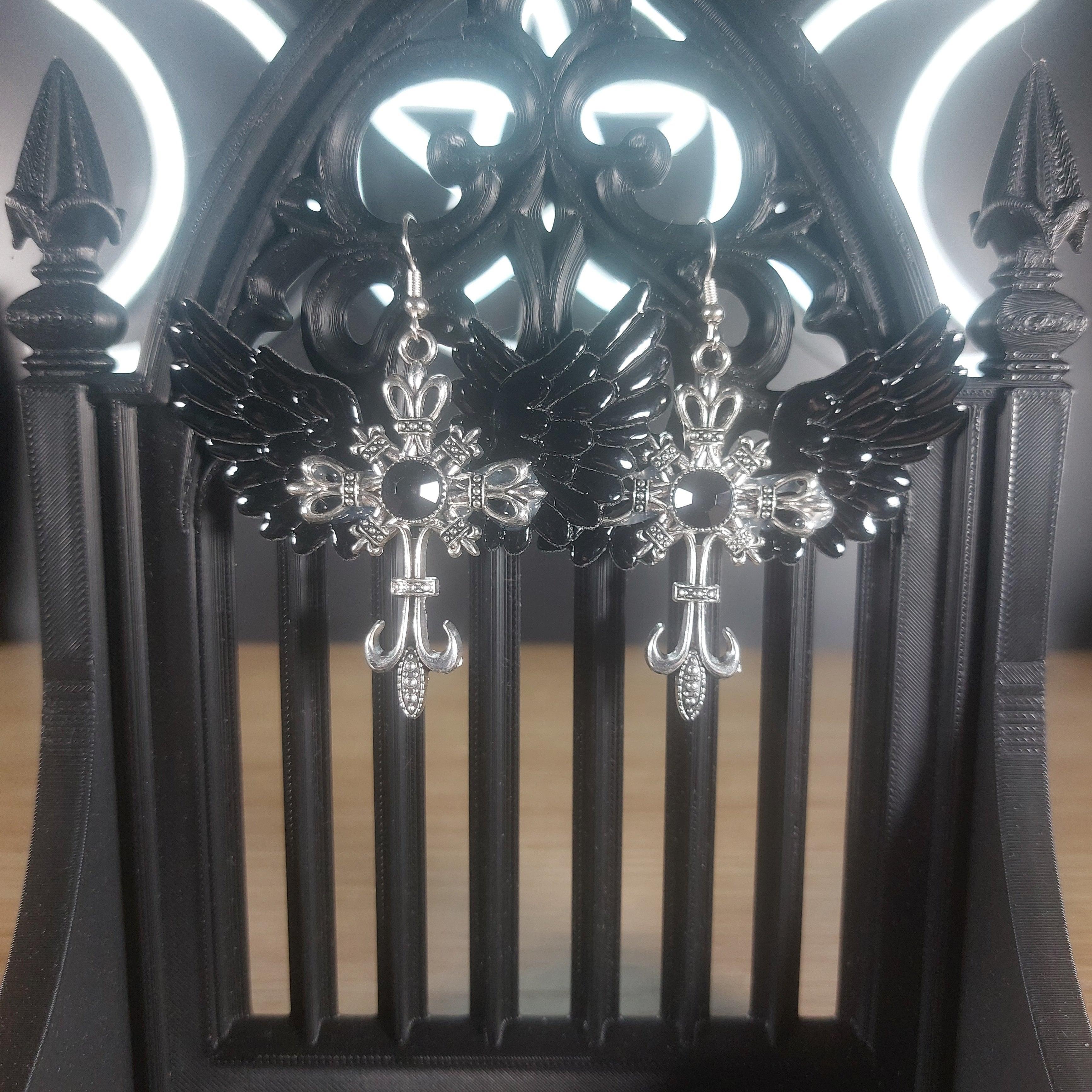 Black winged silver-tone cross dangle earrings with intricate gothic details.