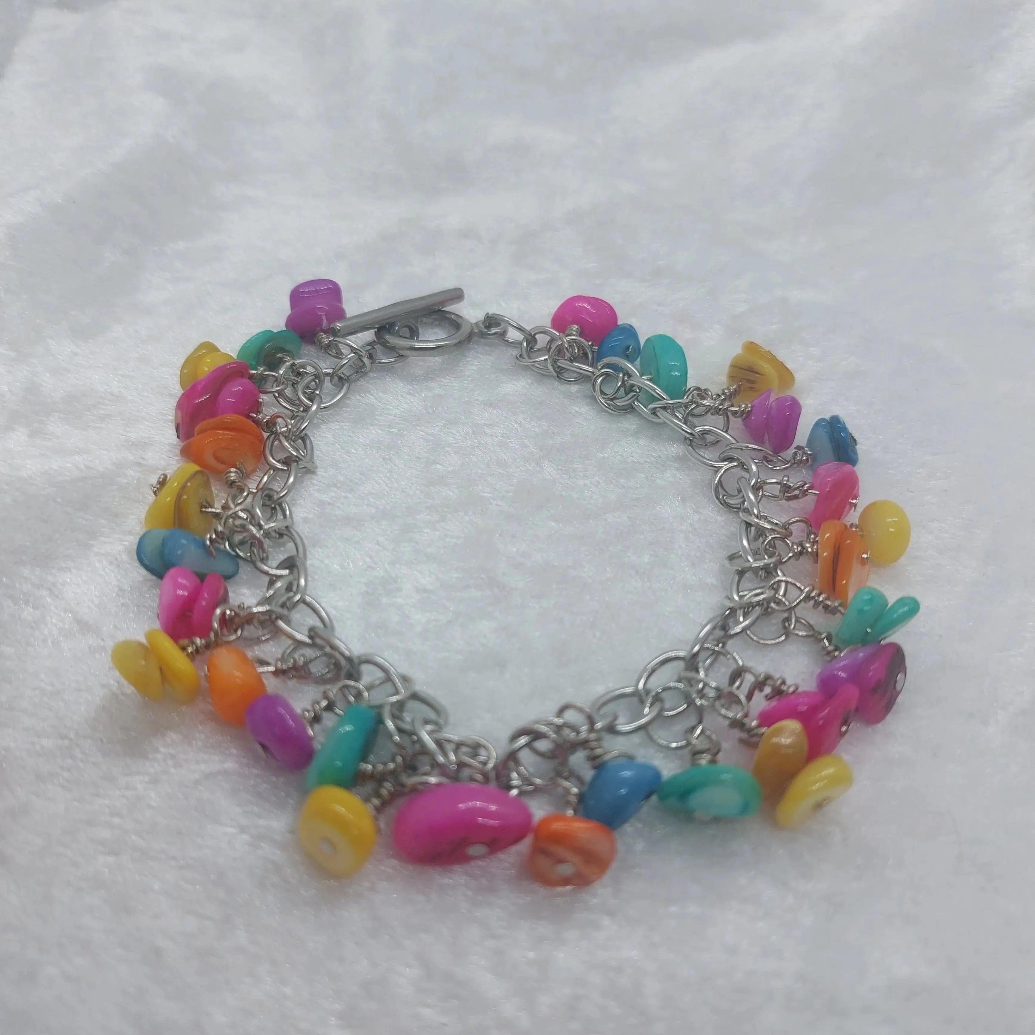 Pastel colored shell bracelet with stainless steel chain and toggle clasp, featuring vibrant pink, yellow, blue, and orange shells.
