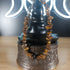 Tigers Eye crystal chip bracelet with stainless steel toggle clasp, displayed on a decorative stand.