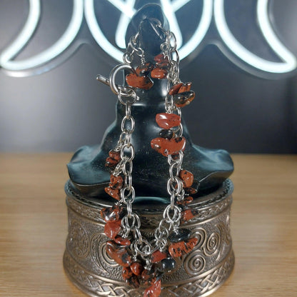 Mahogany obsidian chip bracelet with stainless steel chain on a dark display bust.
