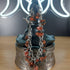 Mahogany obsidian chip bracelet with stainless steel chain on a dark display bust.
