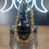 Unakite crystal chip bracelet with green and pink stones, stainless steel toggle clasp, displayed on a black stand.