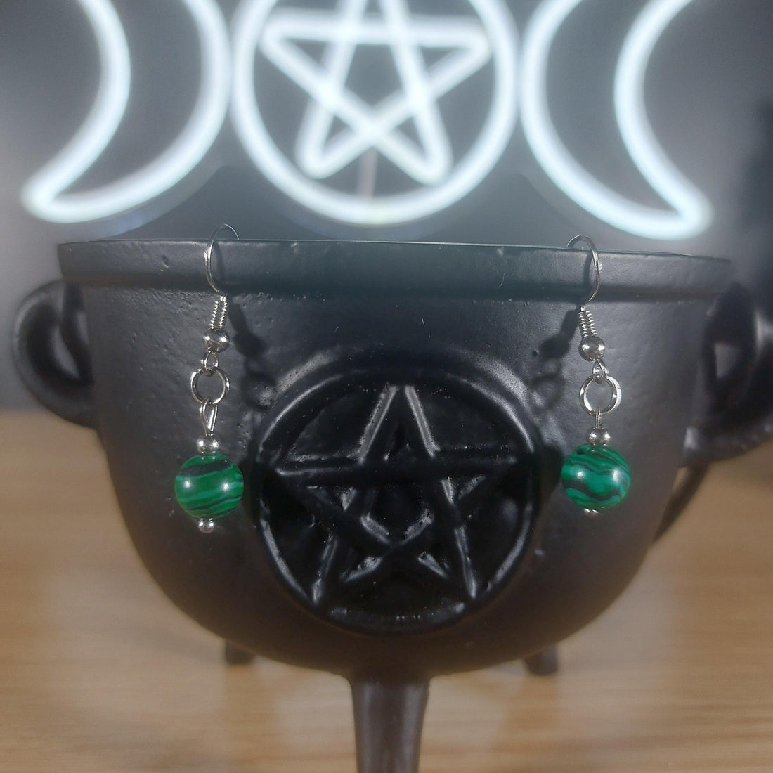 Green malachite crystal beaded dangle earrings on a black cauldron.