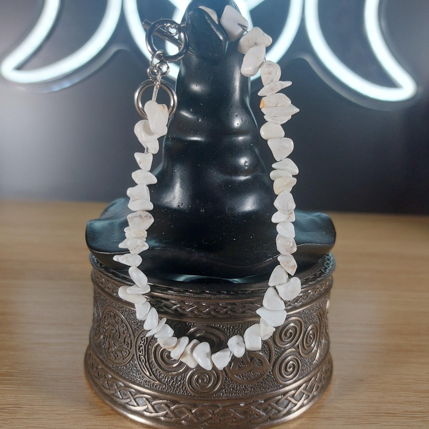 White howlite crystal chip bracelet with a stainless steel toggle clasp, displayed on a black witch hat stand.
