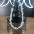 White howlite crystal chip bracelet with a stainless steel toggle clasp, displayed on a black witch hat stand.