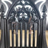 Silver tone broom, witch hat, and crescent moon dangle earrings on a black gothic arch display.