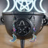 Iridescent glass moon and rainbow star dangle earrings on a black cauldron.