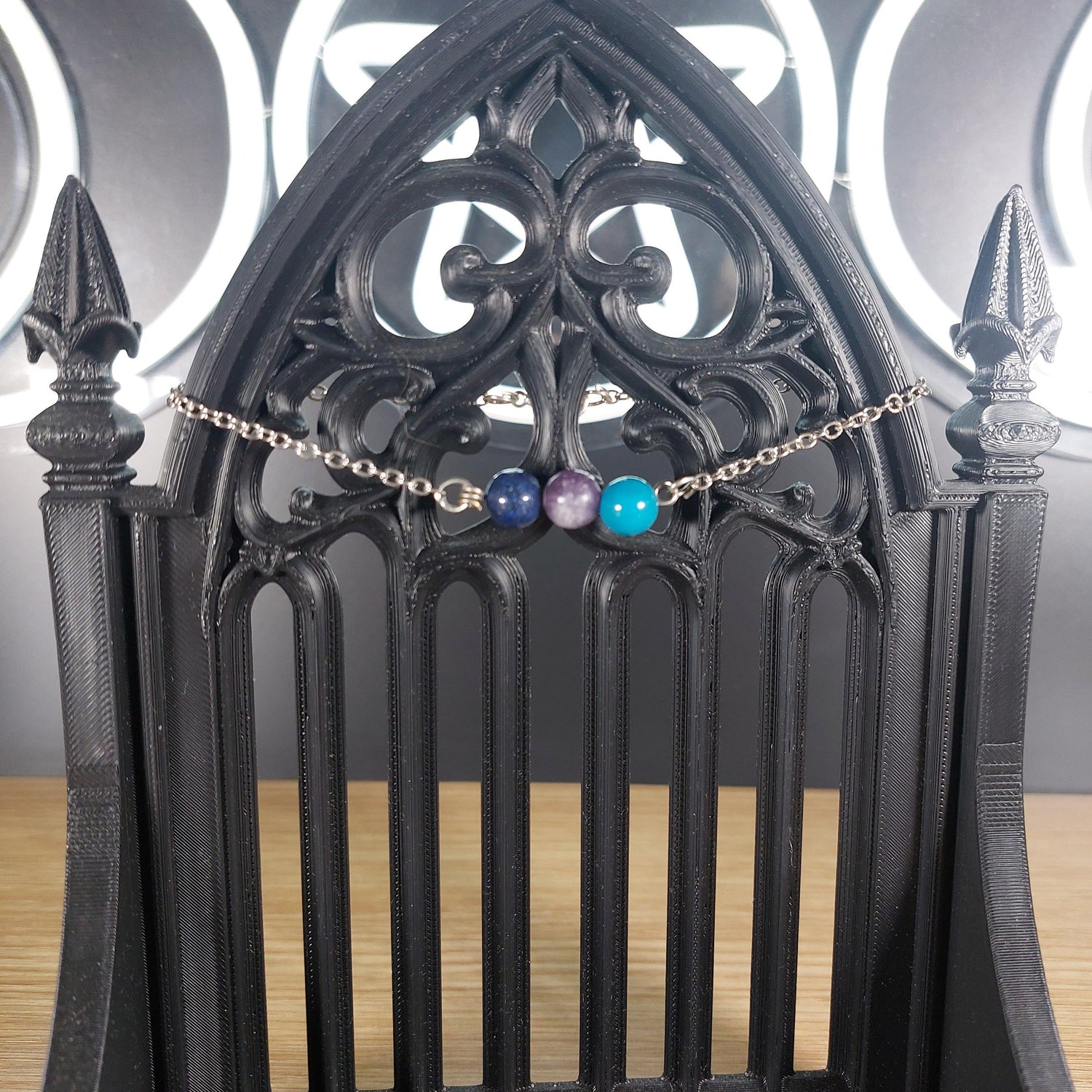 Silver-tone Libra power stone bracelet with blue lace agate, lepidolite, and lapis lazuli beads on a gothic stand.
