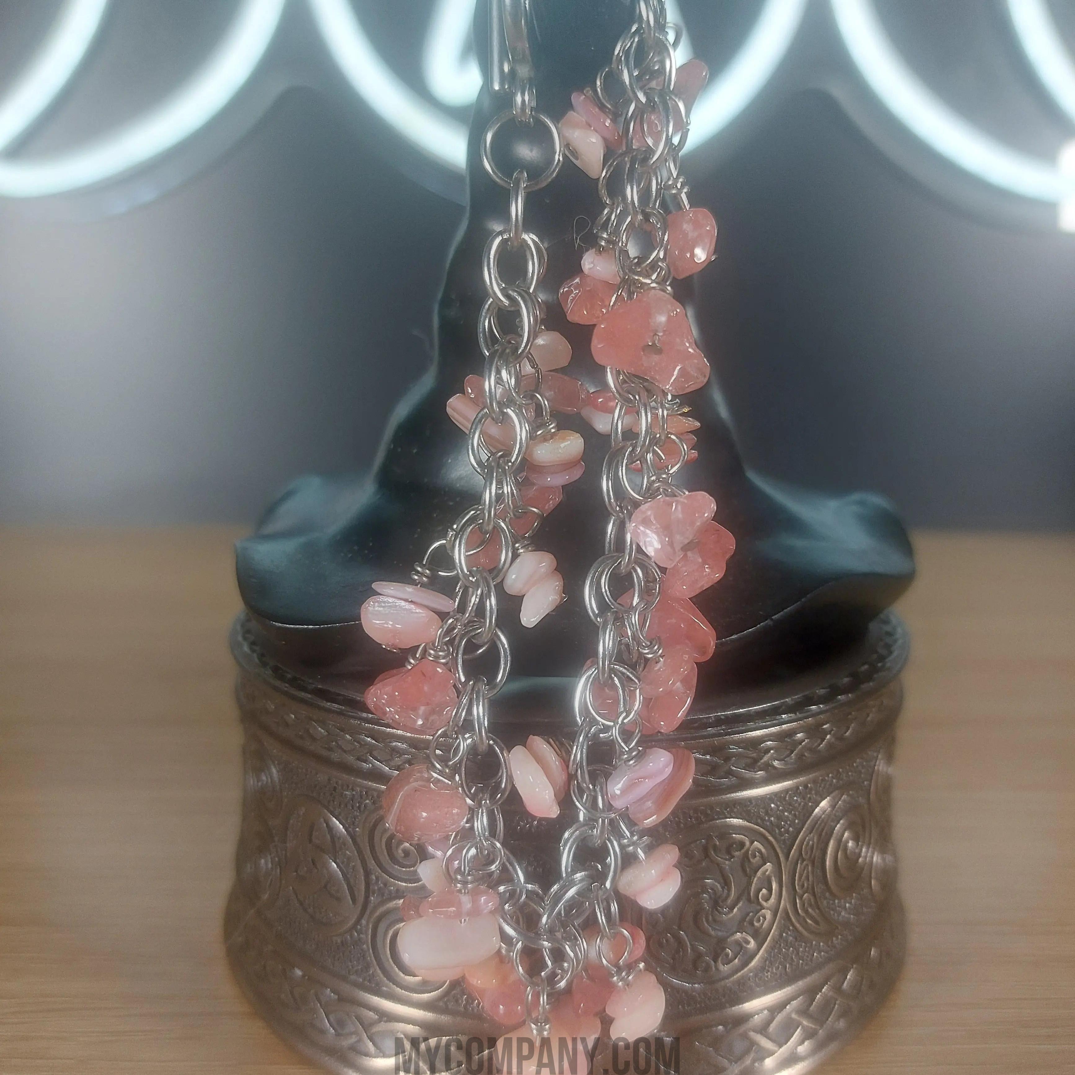 Silver stainless steel chain bracelet with pink coral chip gemstone dangle charms.