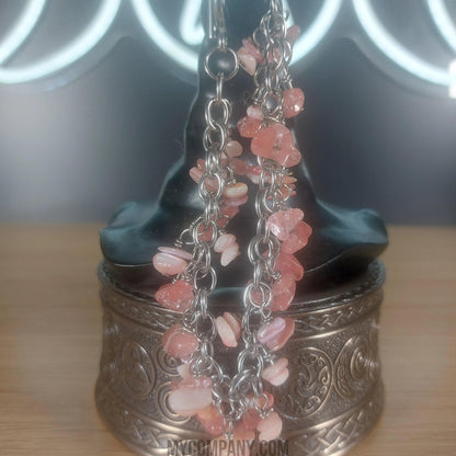 Silver stainless steel chain bracelet with pink coral chip gemstone dangle charms.