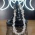 White quartz crystal chip bracelet with a stainless steel toggle clasp, displayed on a black witch hat.