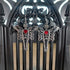 Silver tone skeleton dangle earrings with wings and a red heart, displayed on a black gothic arch.