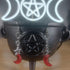 Red glass crescent moon and silver star dangle earrings on a black cauldron.
