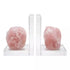 Matched set of two natural rose quartz slab bookends in soft pink with crystalline internal structure, shown propping books on plain surface